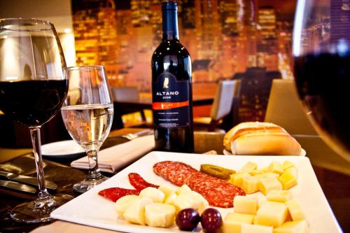 a plate of cheese and meats and a glass of wine at San Michel Palace Hotel in Taubaté