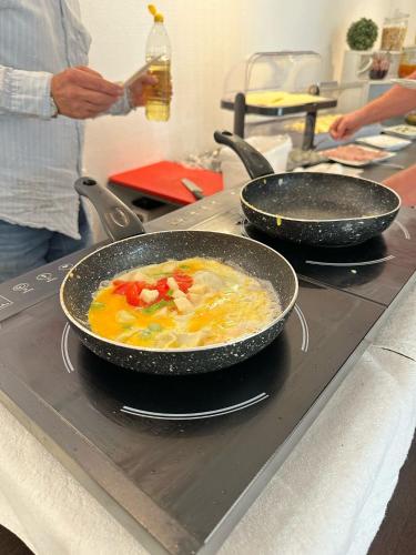 a person cooking food in a pan on a stove at Zum Alten Schulhaus in Burg