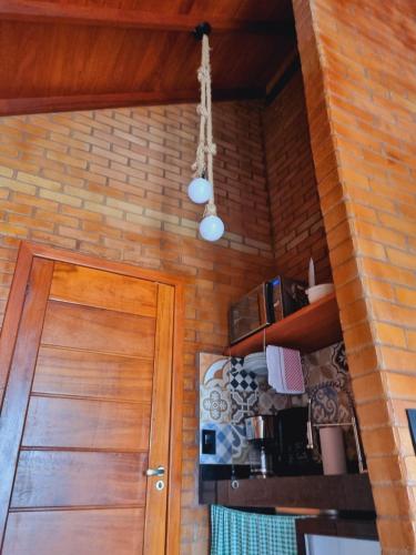 a room with a wooden door and a brick wall at Chalé HOSPEDAGEM in Rio Bananal