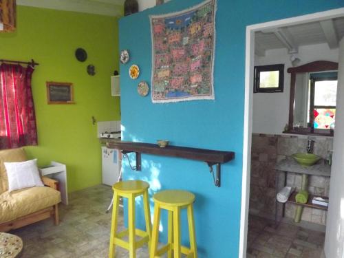a room with two yellow stools and a table on a wall at Kiritina´s House Homestay in El Calafate