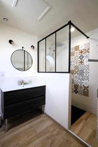 une salle de bain avec un lavabo et un miroir dans l'établissement Maison élégante à Lancieux - Mer confort et sérénité, à Lancieux