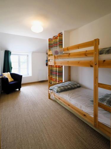 - une chambre avec 2 lits superposés et une chaise dans l'établissement Maison élégante à Lancieux - Mer confort et sérénité, à Lancieux