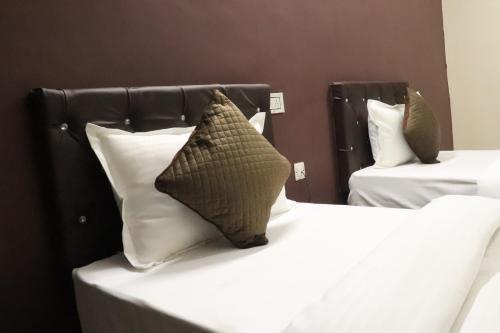 Un dormitorio con dos camas con sábanas y almohadas blancas. en Posh Hotel-Best Business Hotel in Gulbarga, en Gulbarga