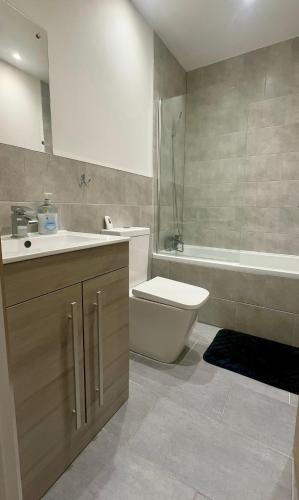 a bathroom with a sink and a toilet and a tub at Spacious 2 Bedroom Flat City Centre in Cannock