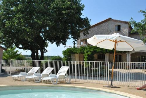 - un groupe de chaises et un parasol à côté de la piscine dans l'établissement Huswell - Rustic Gite with Pool in Southern France, à Saint-Ambroix