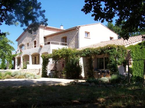 Une grande maison blanche avec du lierre. dans l'établissement Huswell - Rustic Gite with Pool in Southern France, à Saint-Ambroix
