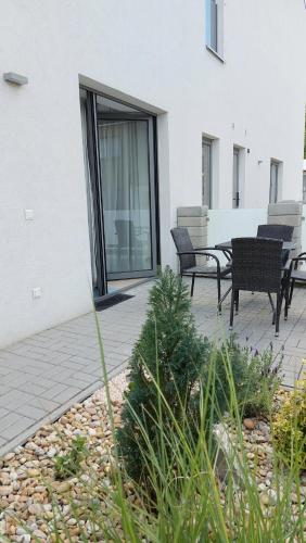 a patio with two chairs and a table in front of a building at Apartmán POD ROTUNDOU in Skalica