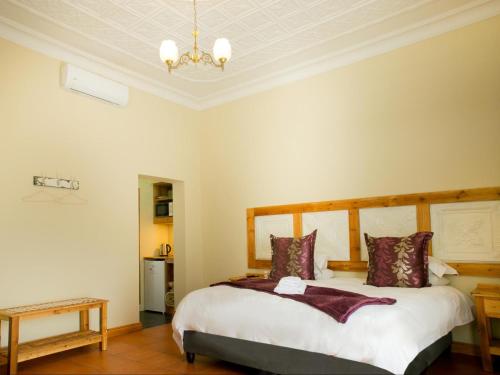 a bedroom with a bed and a chandelier at Nobis House Annex in Bloemfontein