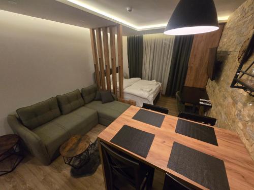 a living room with a green couch and a table at VAB Apartments & SPA, Residence hill, Kopaonik in Kopaonik