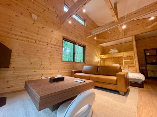 a living room with a couch and a table at Narusawa MADOKA in Wada