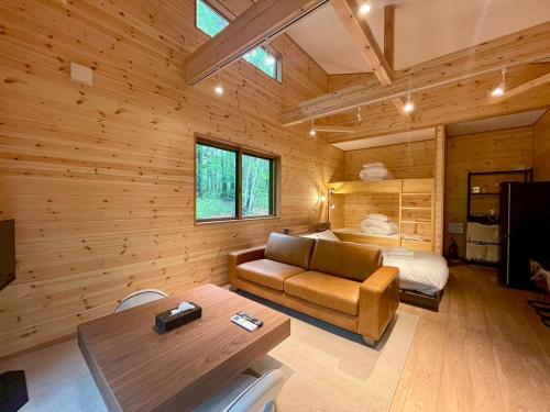 a log cabin bedroom with a couch and a bed at Narusawa MADOKA in Wada