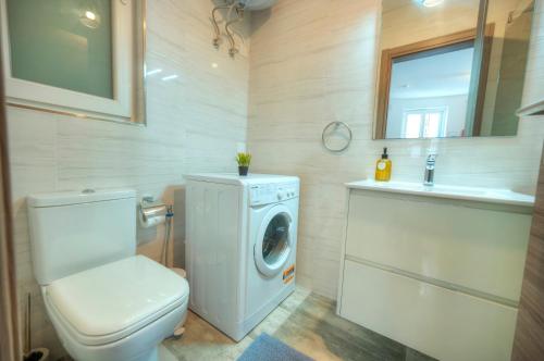 a bathroom with a toilet and a washing machine at Luxury penthouse with jacuzzi on sun terrace APIC1-2 in Misraħ Il-Barrieri