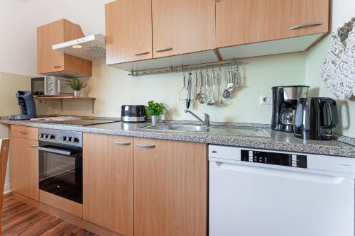 a kitchen with wooden cabinets and a sink at Kajüte Nr 2 in Neue Tiefe Fehmarn