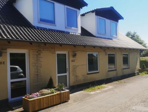 a yellow house with windows and flowers in front of it at HK Homes Apartments in Aarhus