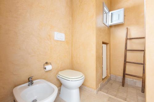 a small bathroom with a toilet and a sink at Villa Emma by BarbarHouse in Spongano