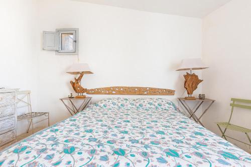 a bedroom with a bed and two lamps on two tables at Villa Emma by BarbarHouse in Spongano