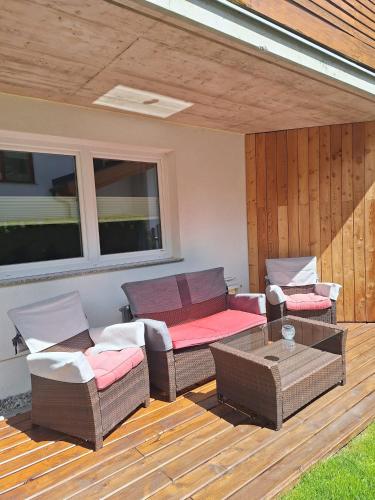 a patio with wicker chairs and a table on a deck at Haus Matthias in Umhausen