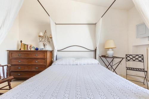 a bedroom with a white bed and a wooden dresser at Villa Emma by BarbarHouse in Spongano