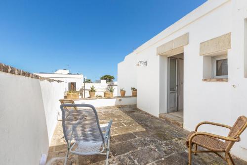 a patio with chairs and tables on a white building at Villa Emma by BarbarHouse in Spongano