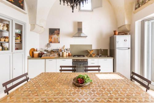 a kitchen with a table with a bowl of fruit on it at Villa Emma by BarbarHouse in Spongano