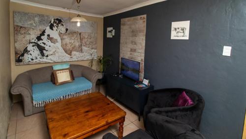 a living room with a dog picture on the wall at Roots Self Catering Unit 1 in Port Elizabeth