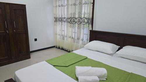 a bedroom with two white beds and a window at White Breeze Villa Ahangama in Ahangama