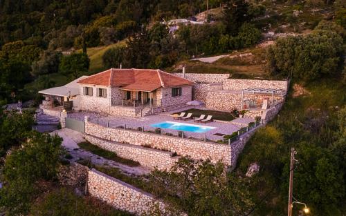 an aerial view of a stone house with a swimming pool at Villa Aurora in Athanion