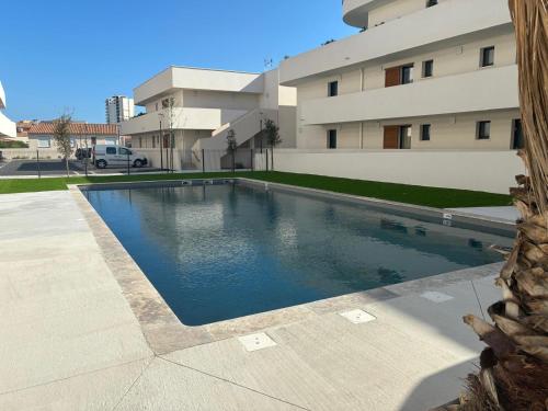 une piscine devant un immeuble dans l'établissement Appartement neuf et climatisé, 6 personnes, avec piscine, à Sérignan