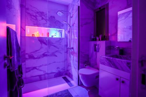 a purple bathroom with a shower and a toilet at Luxury golf Prestigia Saphir in Marrakech