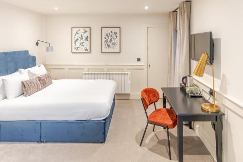 a bedroom with a bed and a desk and a chair at Grove House Hotel in Edinburgh
