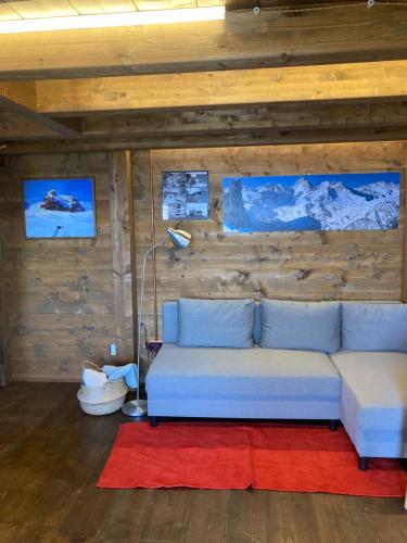 a living room with a blue couch and a red rug at La BAITA in Roccabruna