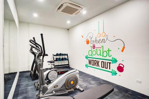 a gym with a treadmill and a wall with a sign at Saltstayz Premier - Arjun Marg in Gurgaon