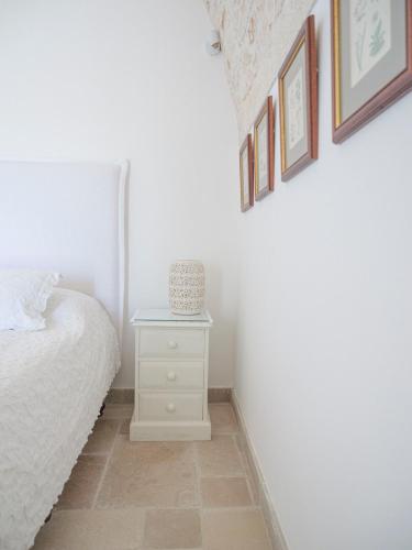 a bedroom with a white bed and a nightstand at Casa Pietra Bianca Fay in Castellana Grotte