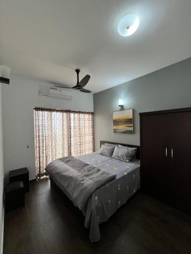 a bedroom with a bed and a ceiling fan at Sea View Apartment in Colombo