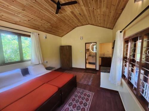 a bedroom with a large bed with a wooden ceiling at Tamarind Tree Masinagudi in Masinagudi