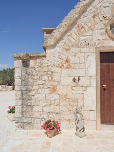 a stone building with a door and a flower pot at Casa Pietra Bianca Fay in Castellana Grotte