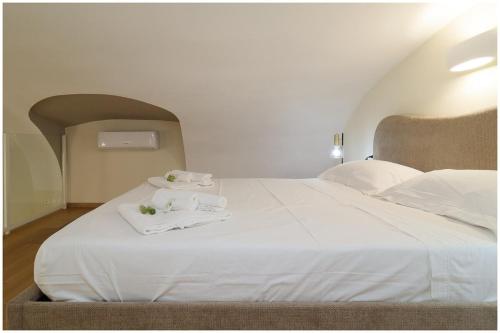 a bedroom with a white bed with towels on it at Piave X Design Loft Quadrilatero WiFi AC in Turin