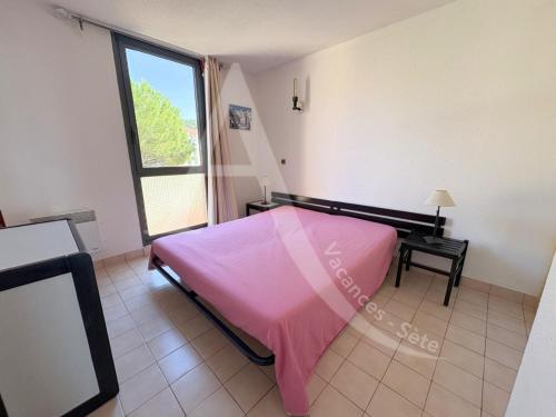 - une chambre avec un lit rose et une fenêtre dans l'établissement APPARTEMENT 46M², 1 CHAMBRE, PISCINE, TENNIS, PLAGE DIRECT, à Sète