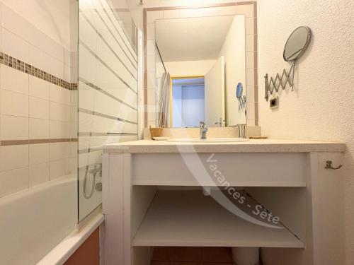 une salle de bain avec un lavabo et un miroir dans l'établissement APPARTEMENT 46M², 1 CHAMBRE, PISCINE, TENNIS, PLAGE DIRECT, à Sète