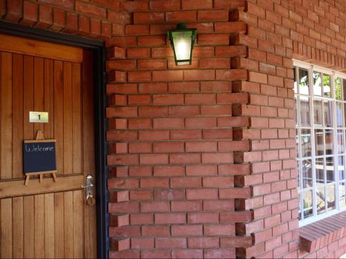 a brick wall with a door and a light at The Wooden Spoon Guesthouse in Bethlehem