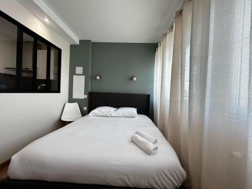 a bedroom with a bed with two towels on it at La Suite Faïence, chic et calme in Panazol