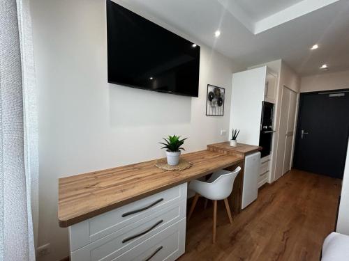 a kitchen with a desk with a television on the wall at La Suite Faïence, chic et calme in Panazol
