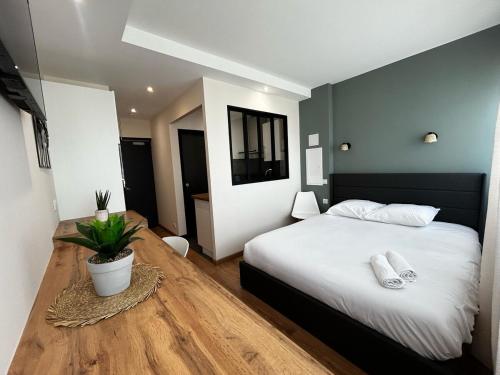 a bedroom with a white bed and a wooden floor at La Suite Faïence, chic et calme in Panazol