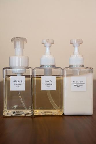 three bottles of perfume sitting on a wooden table at 一棟貸し宿 松本邸 in Kinoe