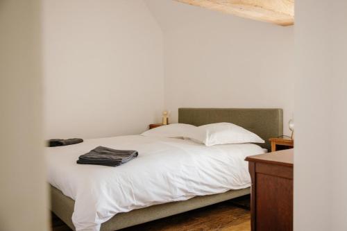 a bedroom with a bed with white sheets and pillows at Pied à Terre in Bain-de-Bretagne