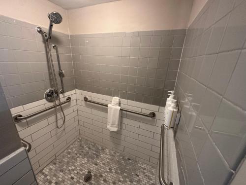 a bathroom with a shower with white tiled walls at Days Inn by Wyndham Farmington NM in Farmington
