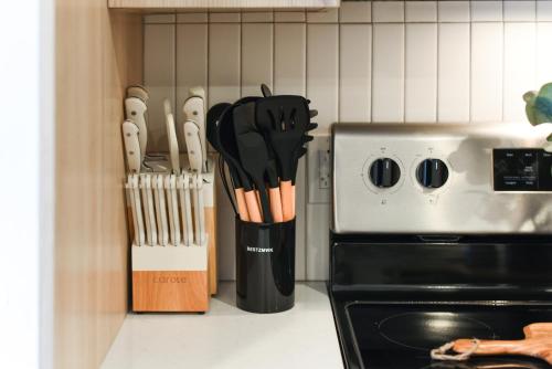 a knife block filled with wooden utensils next to a stove at LUX Studio King Bed Gym Free Parking in Pittsburgh