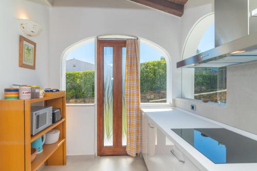 a kitchen with an arched window and a kitchen counter at San Teodoro Villa Ambra Costa Caddu in San Teodoro
