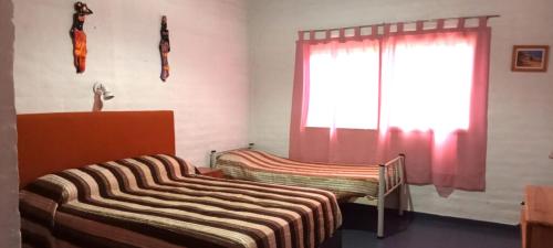 a bedroom with two beds and a window at La flor del lugar in Potrerillos