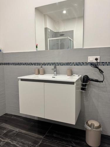 a bathroom with a white sink and a mirror at Il tulipano in Ventimiglia